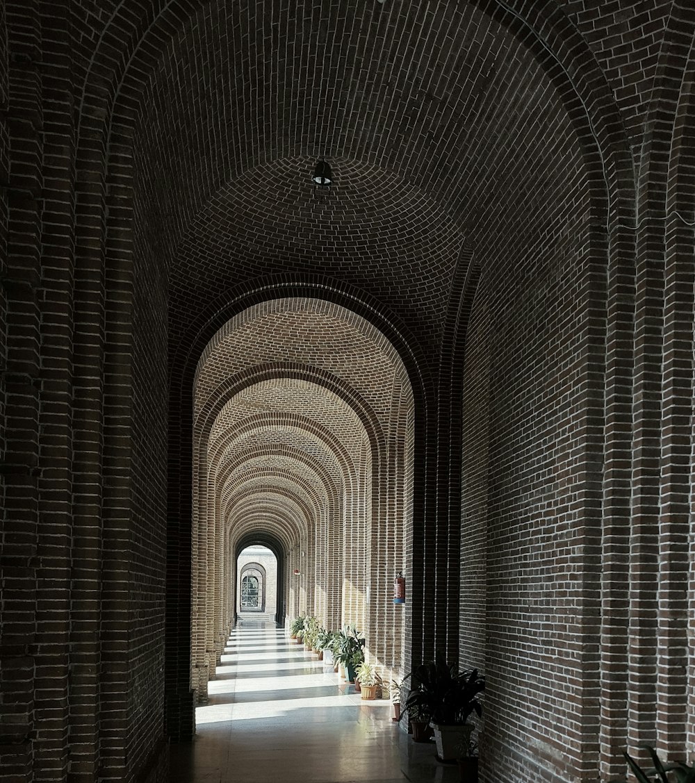 a long hallway with brick walls and arches