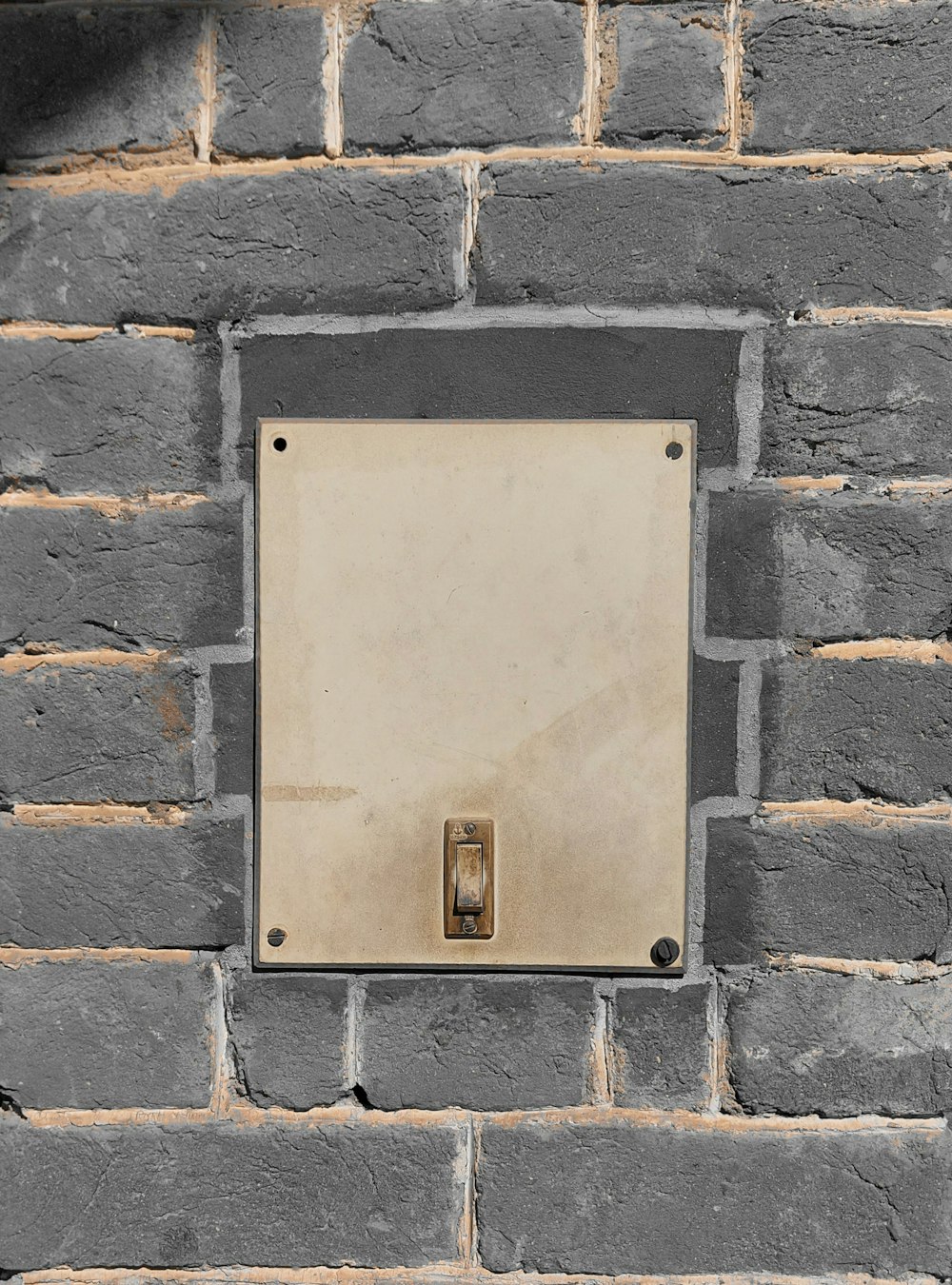 una pared de ladrillo con un interruptor de luz