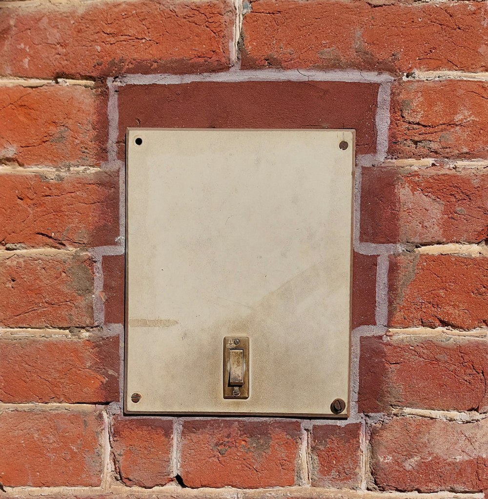 una pared de ladrillo con una caja de metal