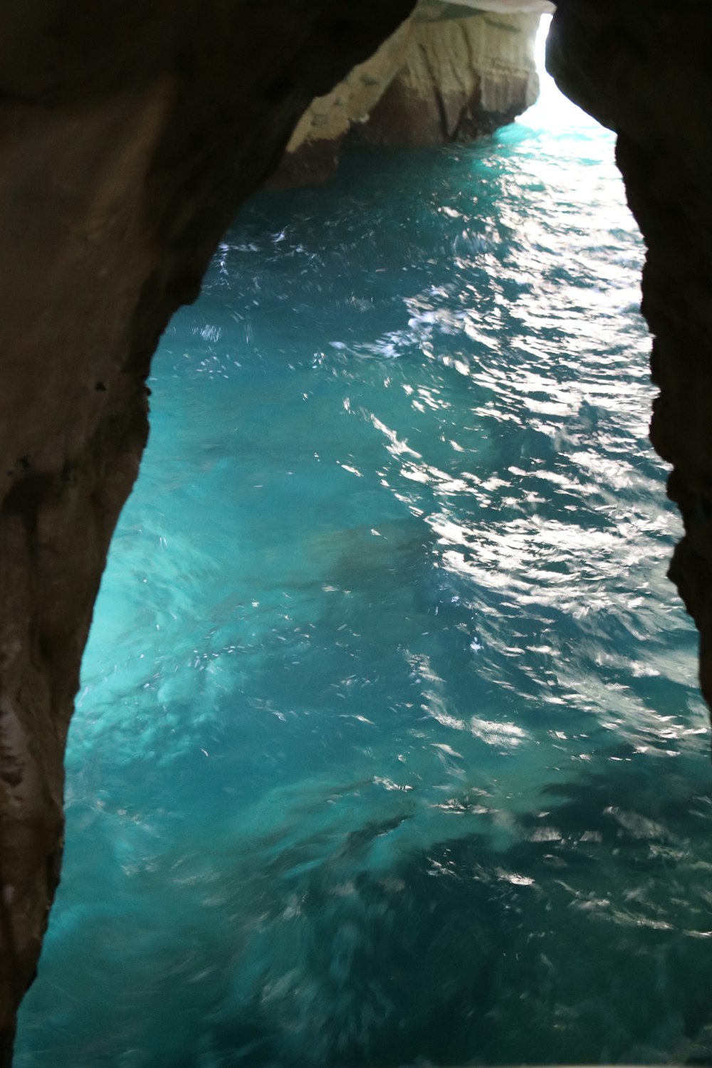 a view of a body of water from inside a cave