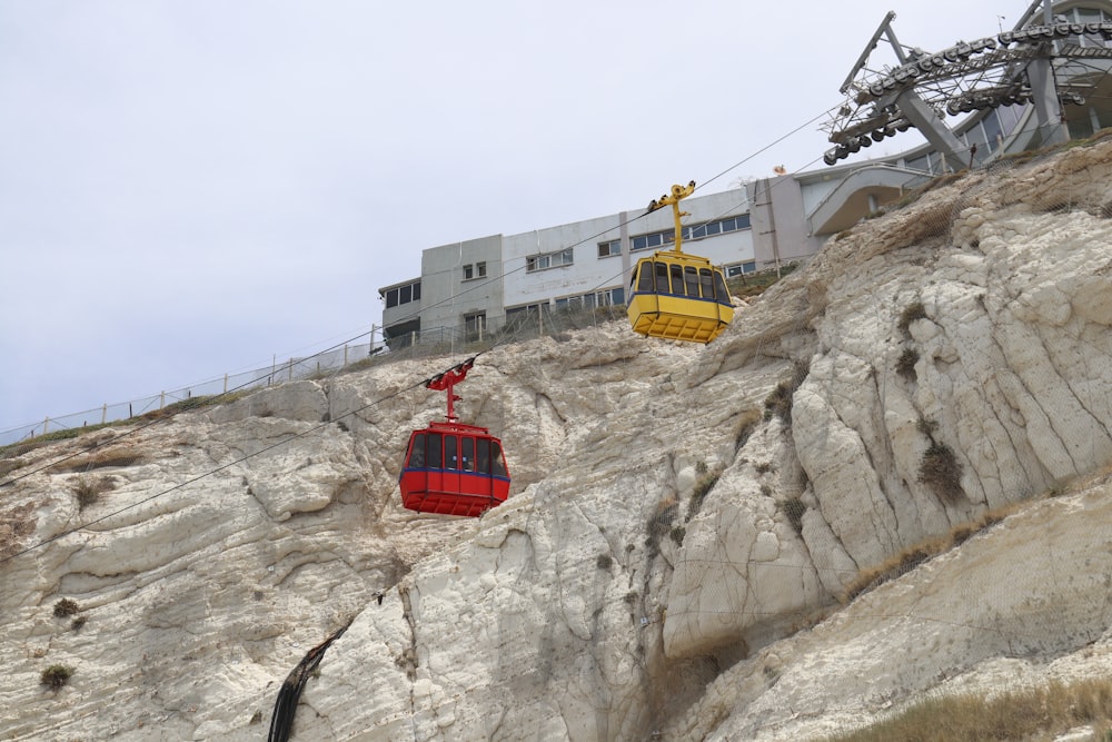 a red and yellow cable car going up a mountain