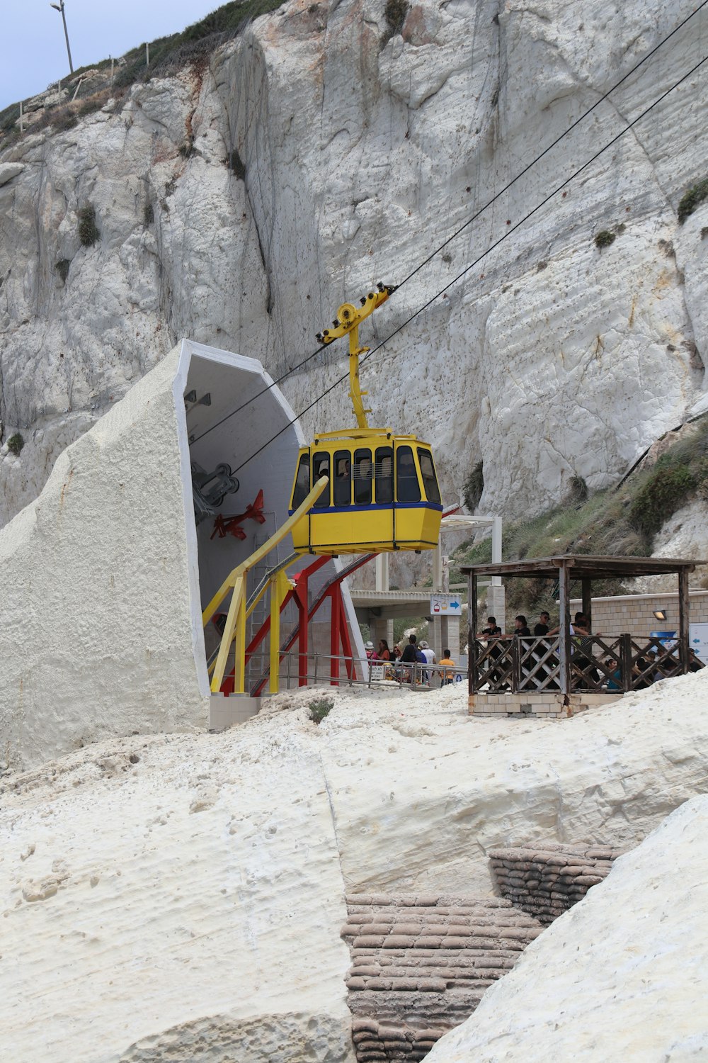 a yellow and white ski lift going up a mountain