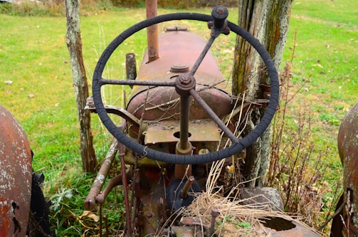 a steering wheel on an old rusted out tractor
