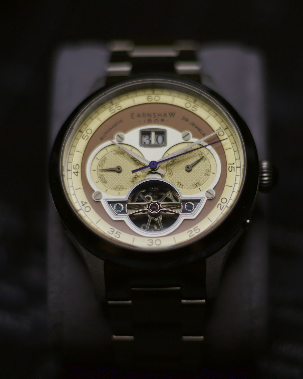 a close up of a watch on a black surface