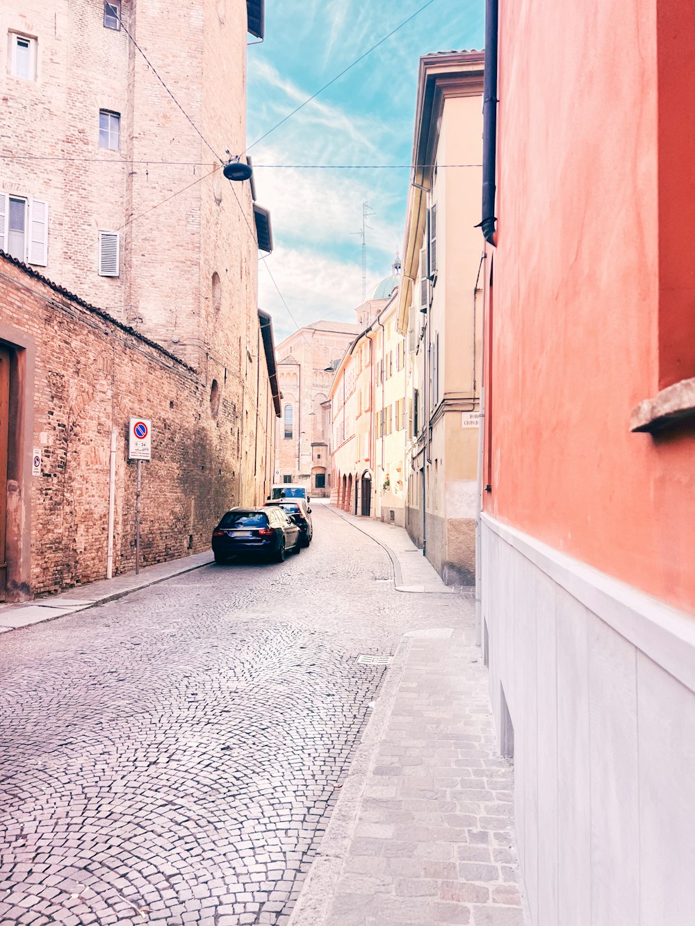 a car is parked on a cobblestone street