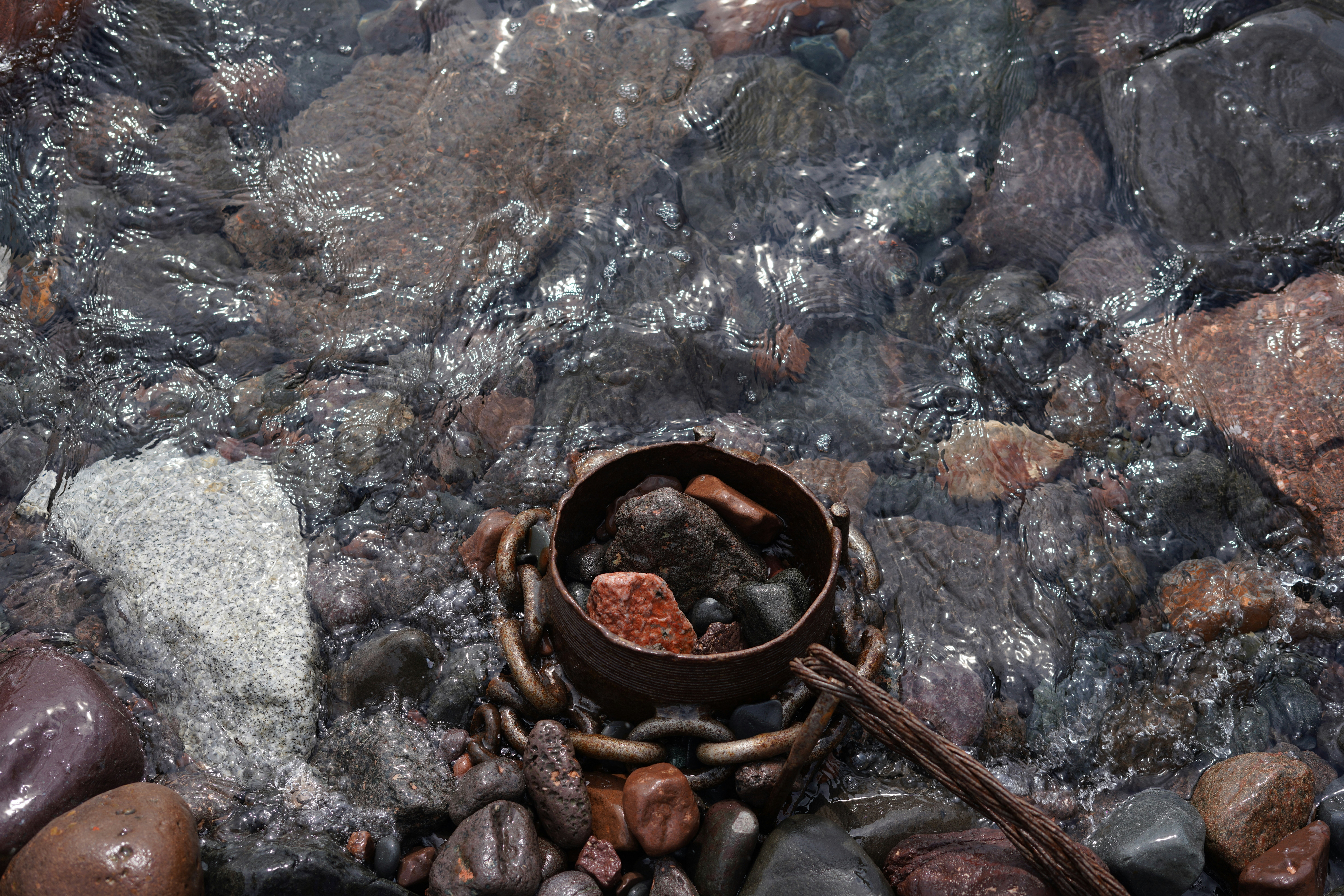 a bowl of rocks sitting on top of a river