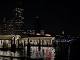 Nighttime cityscape of San Francisco with glowing lights reflecting on the bay waters.