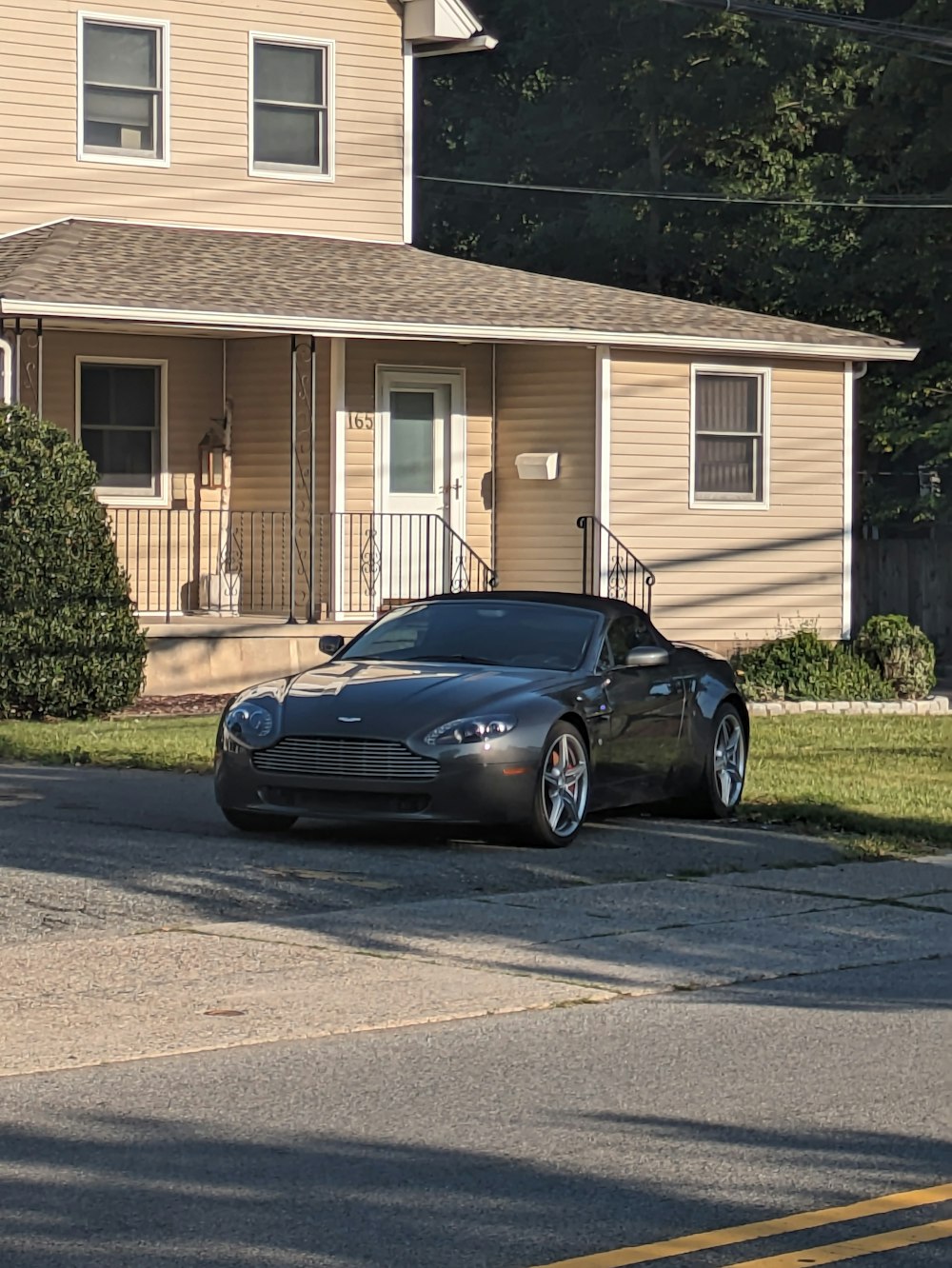 a black sports car parked in front of a house