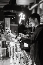 Trainer coaching bartenders in a stylish, modern bar setting with mixology tools.