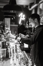 Trainer coaching bartenders in a stylish, modern bar setting with mixology tools.