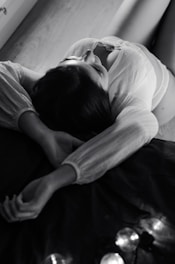a black and white photo of a woman laying on a bed