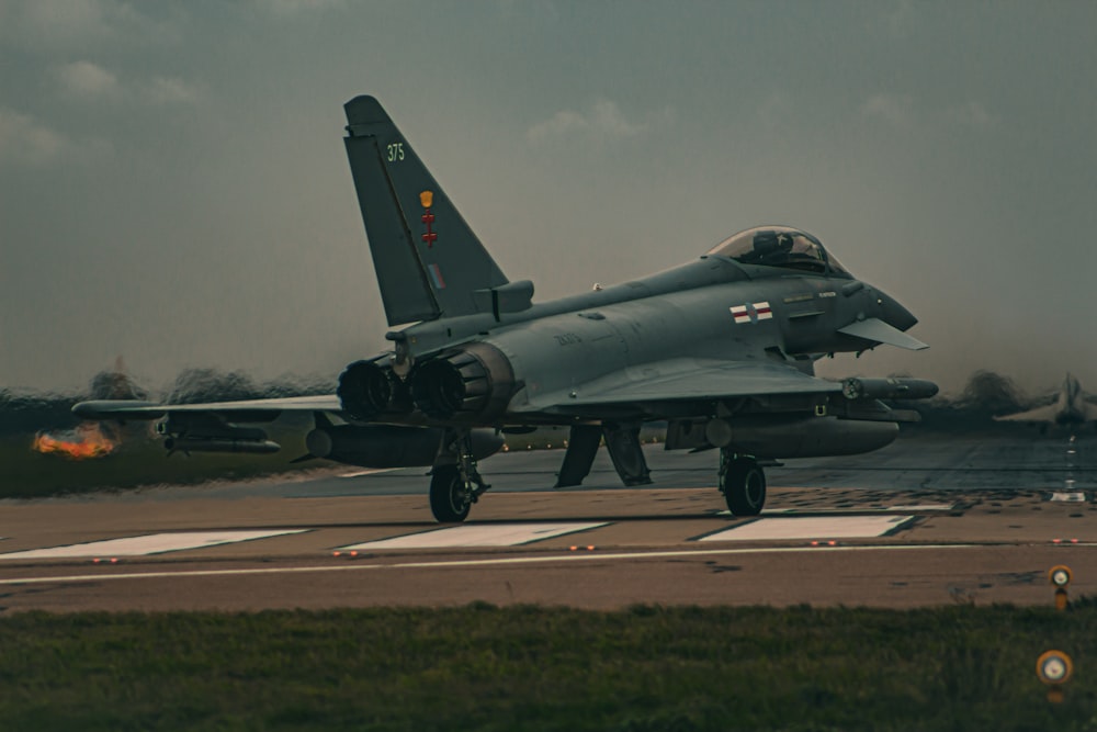 a fighter jet sitting on top of an airport runway