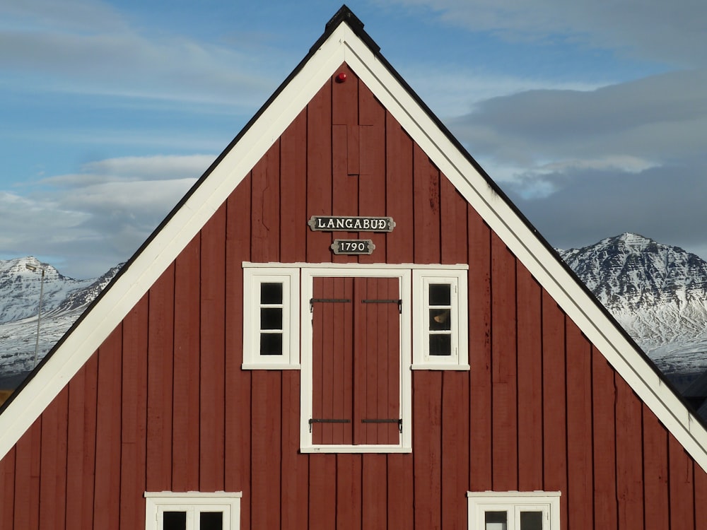 a red building with a white roof and two windows