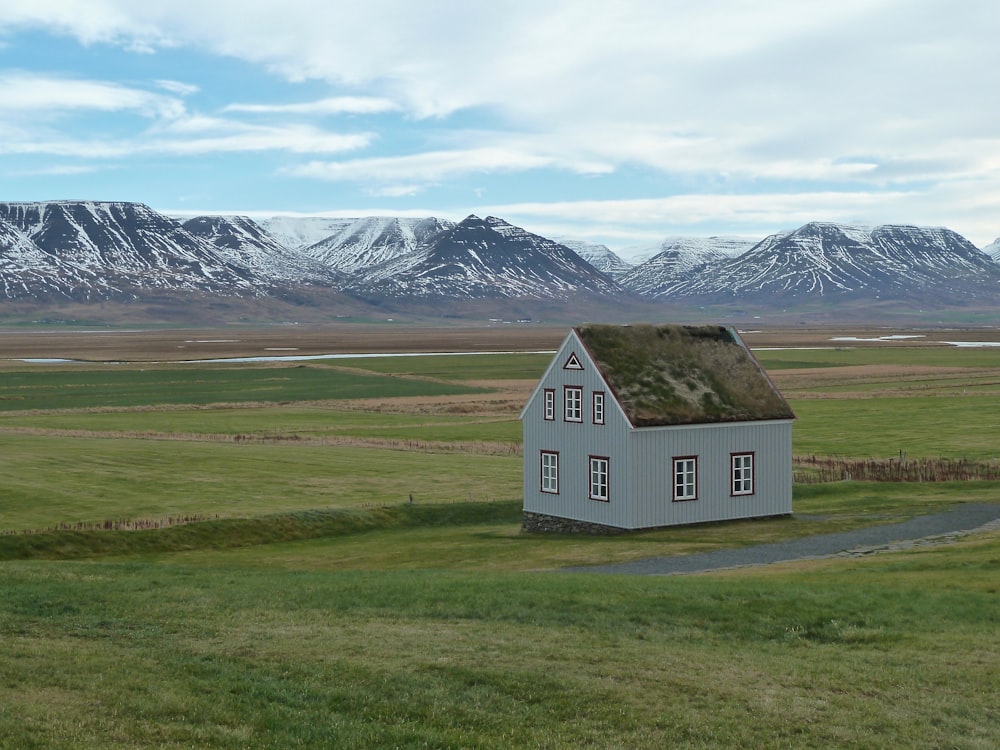 a small white house with a grass roof