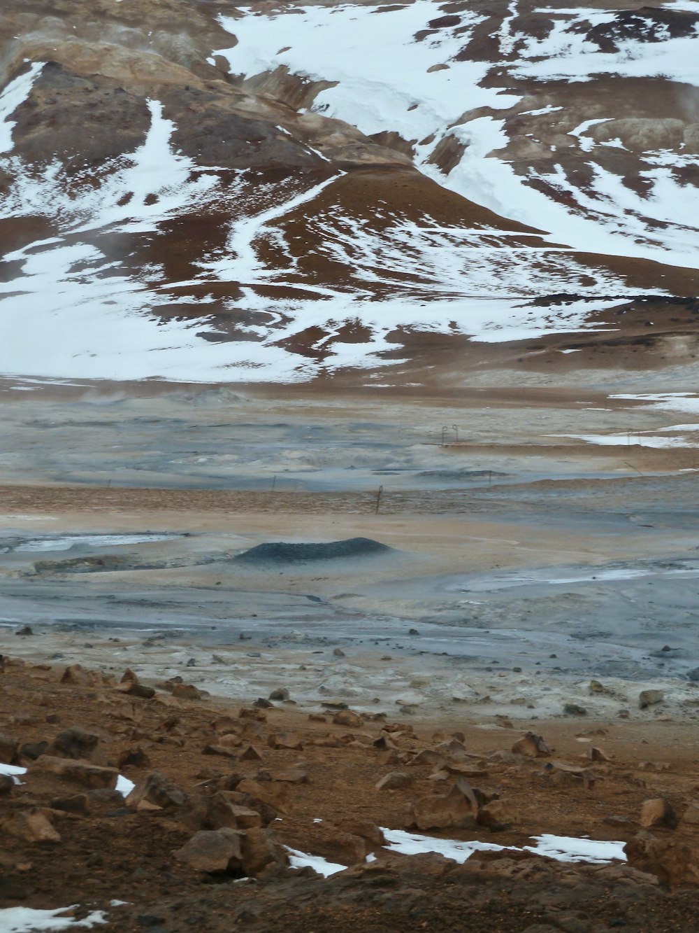 una montaña cubierta de nieve junto a un cuerpo de agua