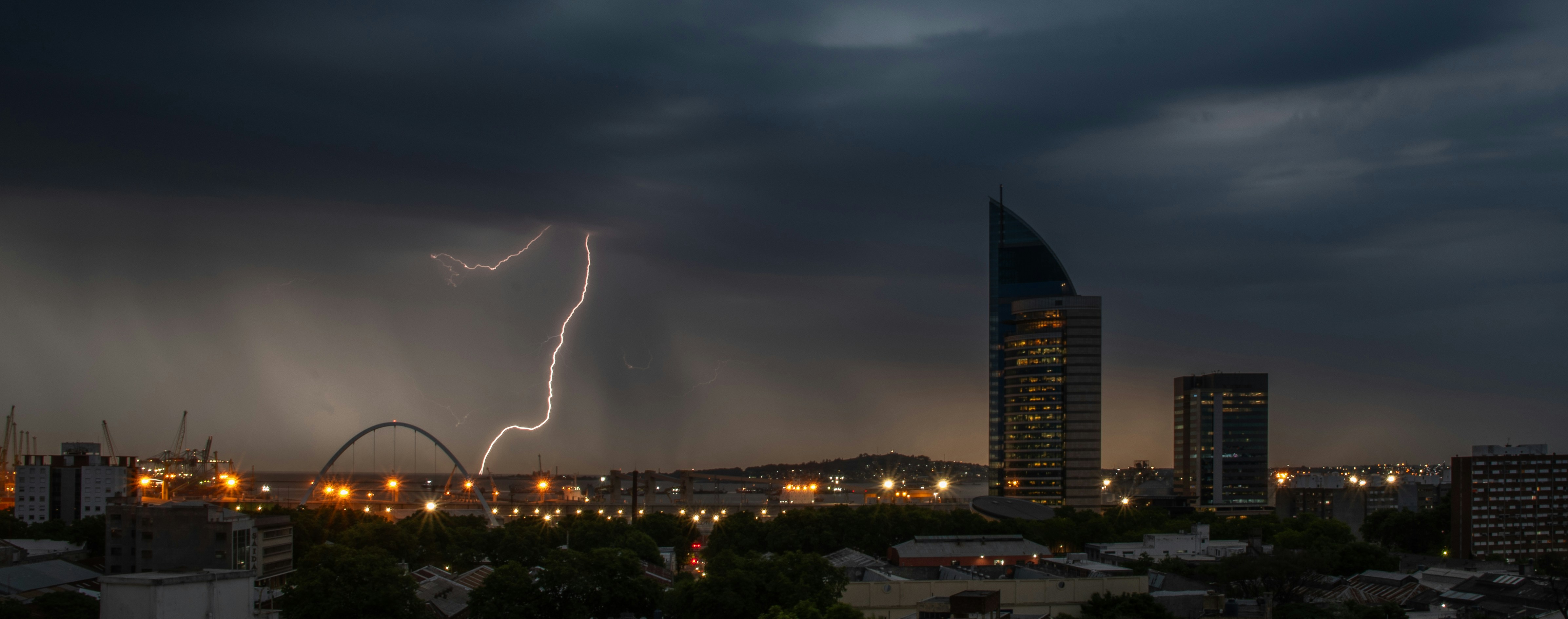 A lightning bolt strikes over a city at night photo – Free Montevideo ...