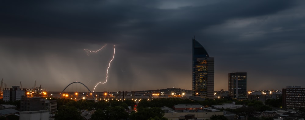 a lightning bolt strikes over a city at night