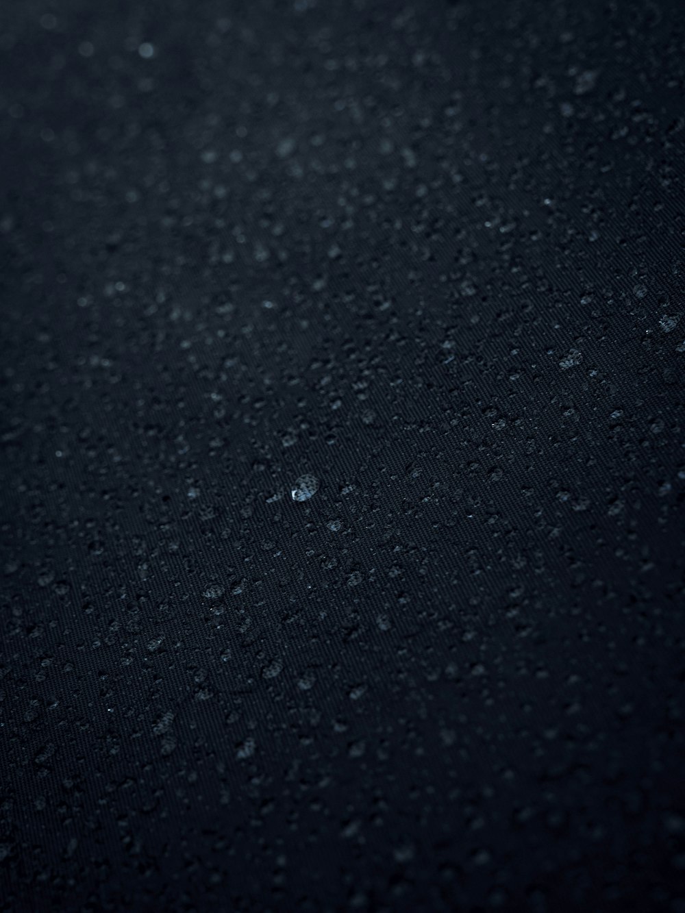 un primer plano de gotas de agua sobre una superficie negra