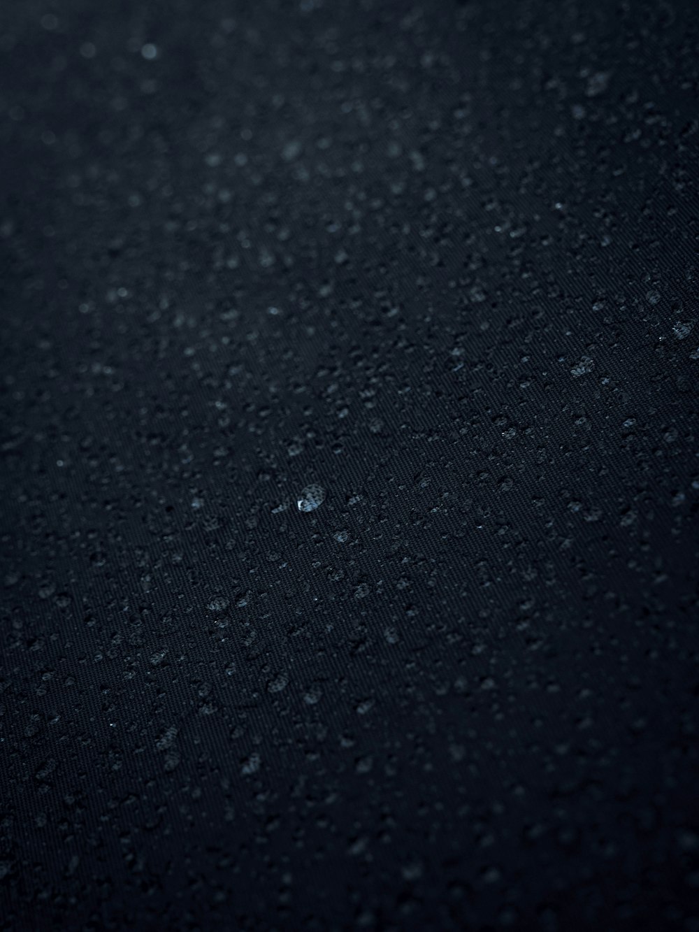 a close up of water droplets on a black surface