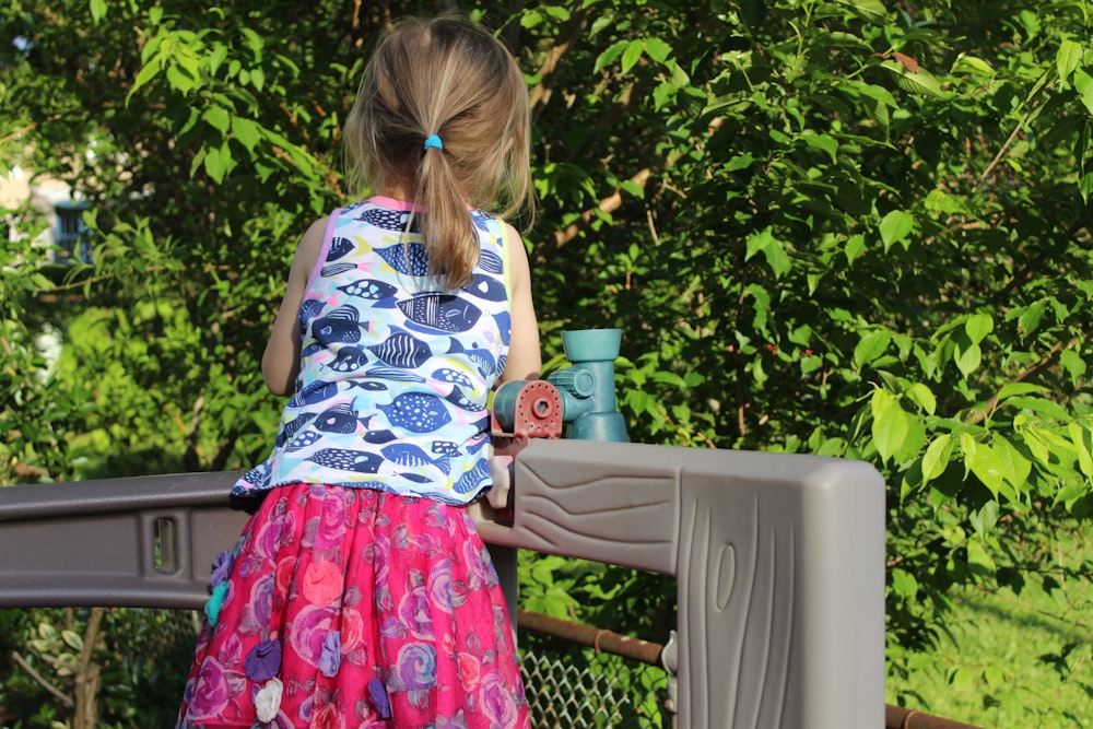 a little girl is standing on a bridge