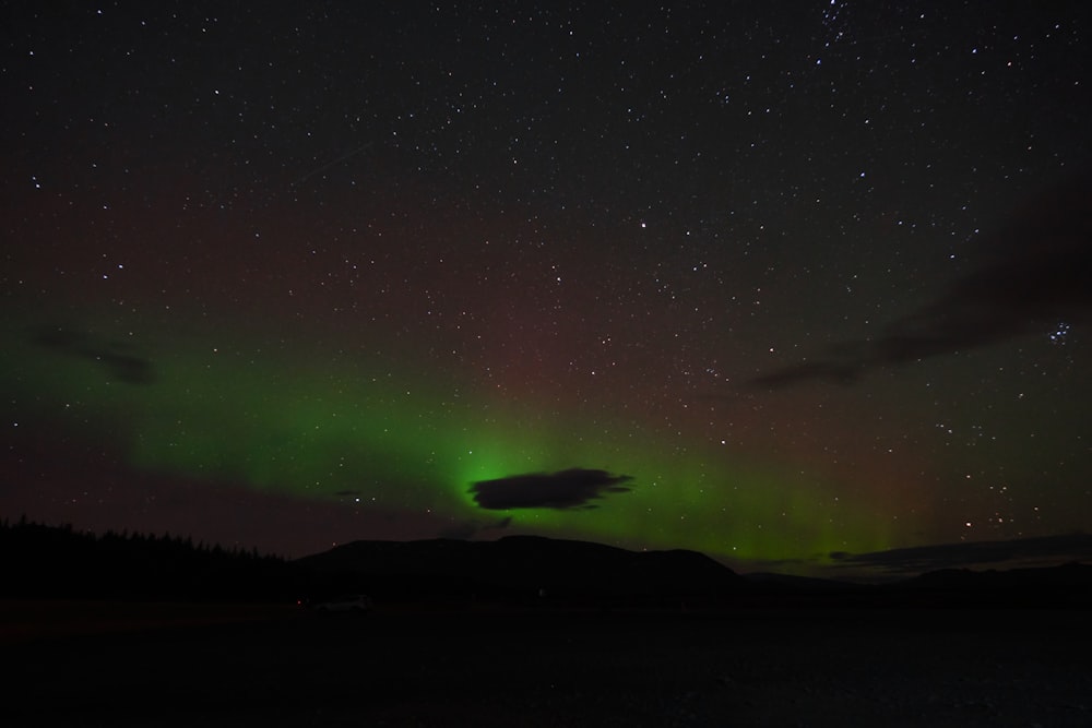 Uma aurora verde e vermelha no céu noturno