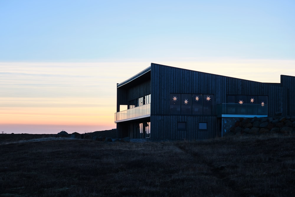 a black building with lights on it sitting on a hill