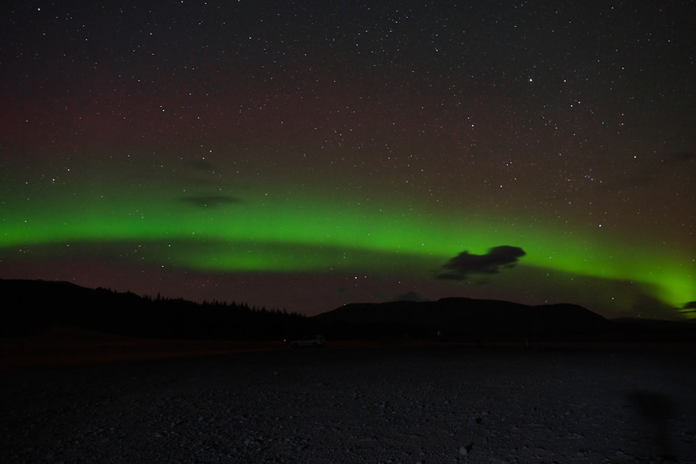 a green and red aurora bore in the night sky