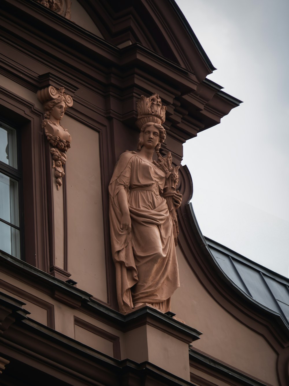 a statue of a woman on the side of a building