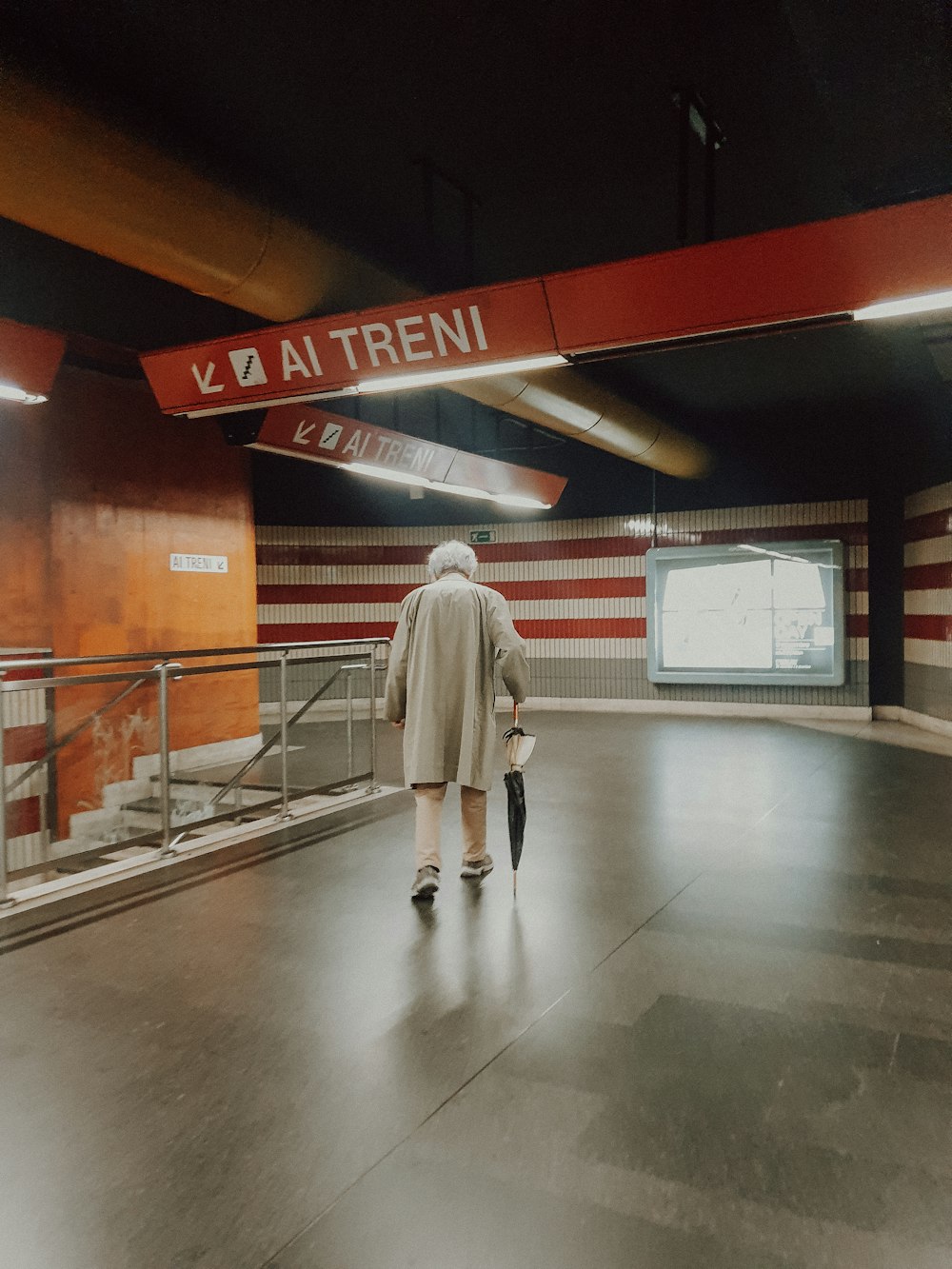 a person walking down a walkway in a building