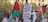 A protest scene with multiple Palestinian flags waving in the air. A prominent sign in the center reads 'Boycott, Divestment, Sanctions and Make Your Own Hummus.' Several other placards are visible with various messages. Trees and a building can be seen in the background.