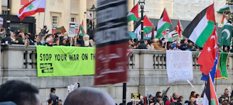 A peaceful crowd holding banners with climate and peace symbols in front of Place de la République.