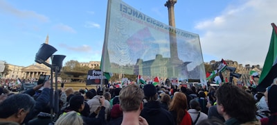A large crowd of Iranian protesters holding banners in a public square during a national gathering.