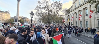 A diverse group of people holding Dutch flags, standing together in a city square, symbolizing unity and hope.