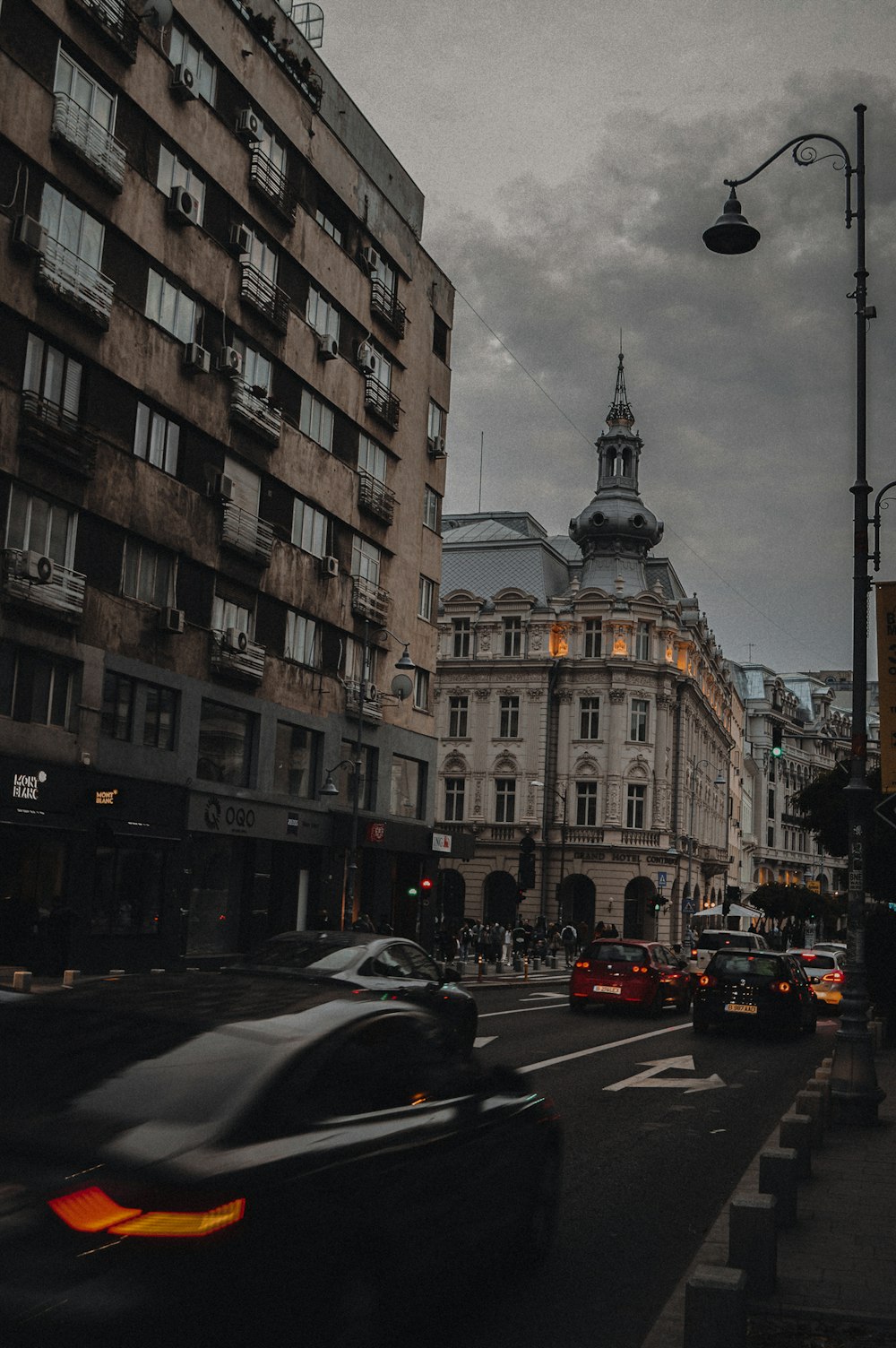 a city street filled with traffic next to tall buildings