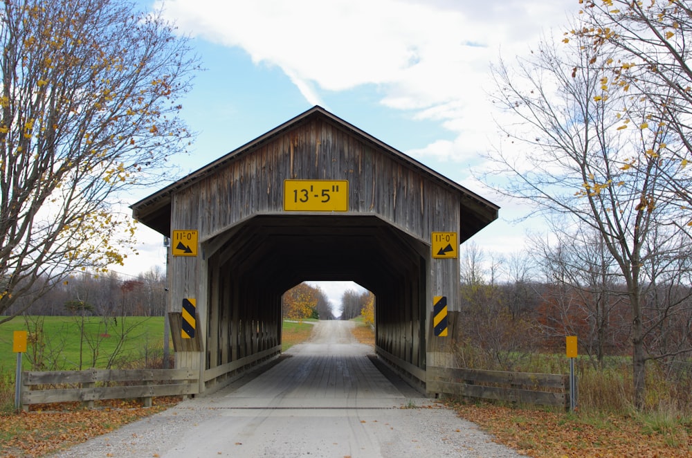 a wooden covered bridge with a road going under it