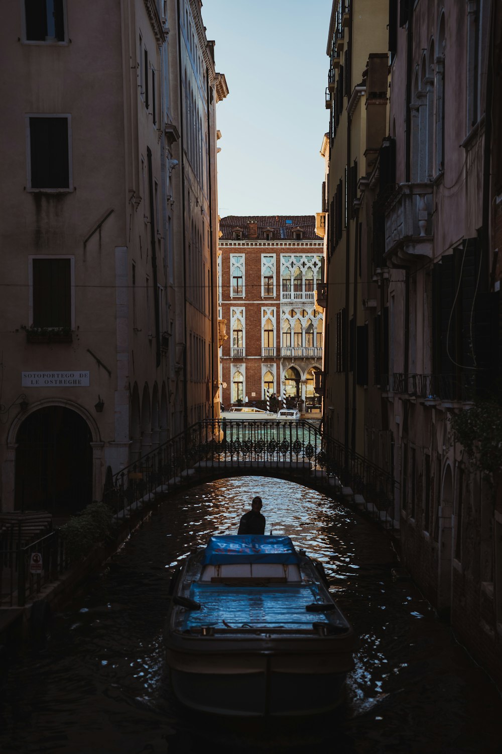 a boat floating down a river next to tall buildings