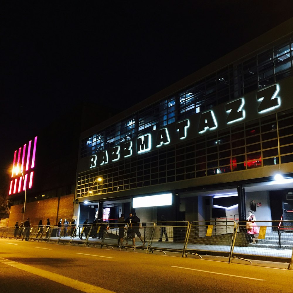 a group of people standing outside of a building at night