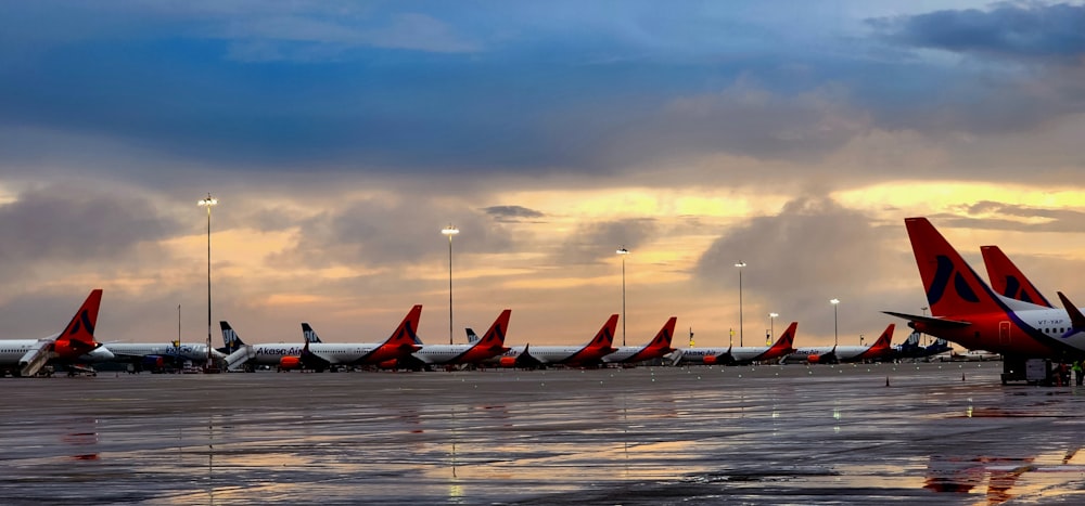 a row of airplanes sitting on top of an airport tarmac