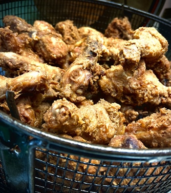 A basket filled with golden-brown chicken buns ready to serve.