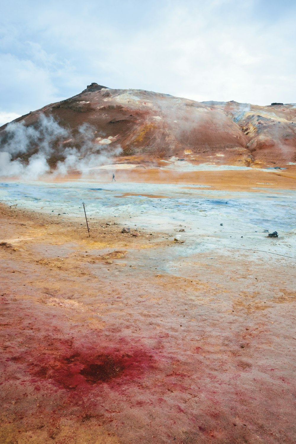 a red substance is on the ground in front of a mountain