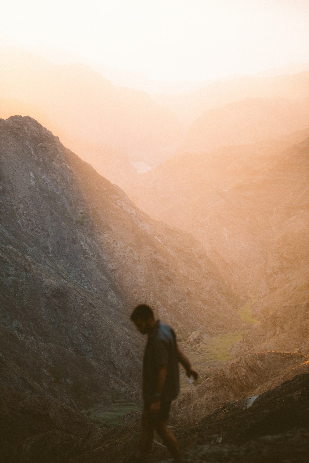 a man standing on top of a mountain next to a valley