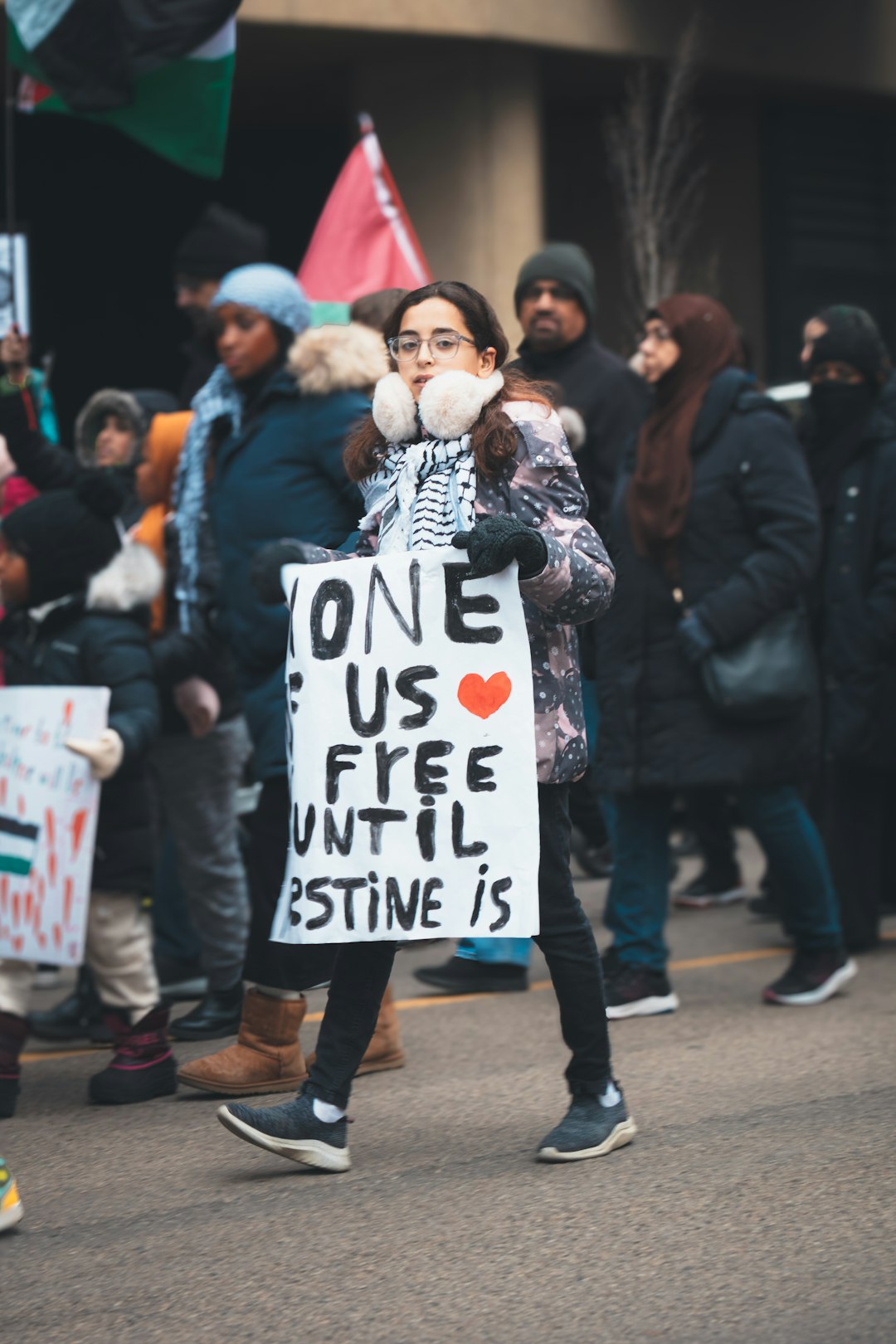 a woman holding a sign that says one us free until stine is