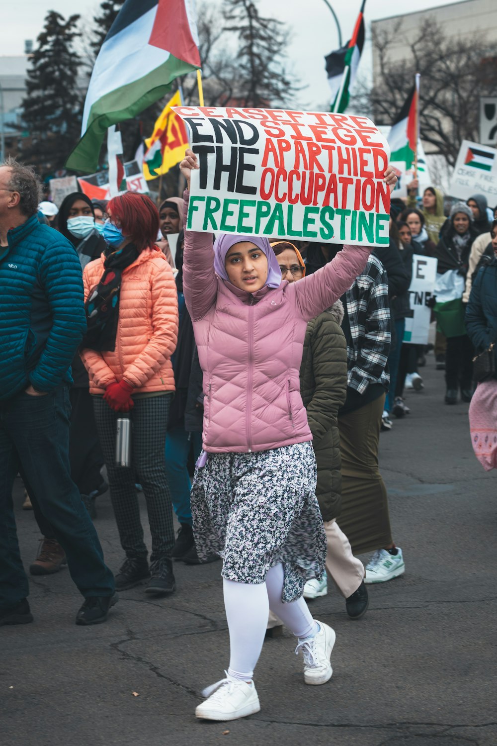 a woman holding a sign that reads free palestine