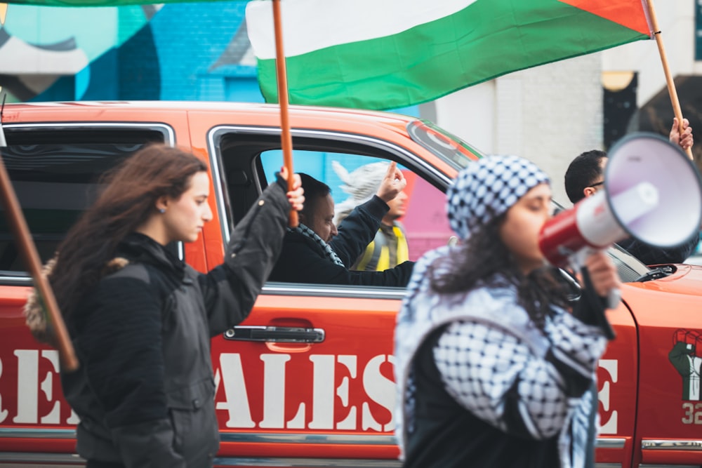 a group of people walking down a street holding flags