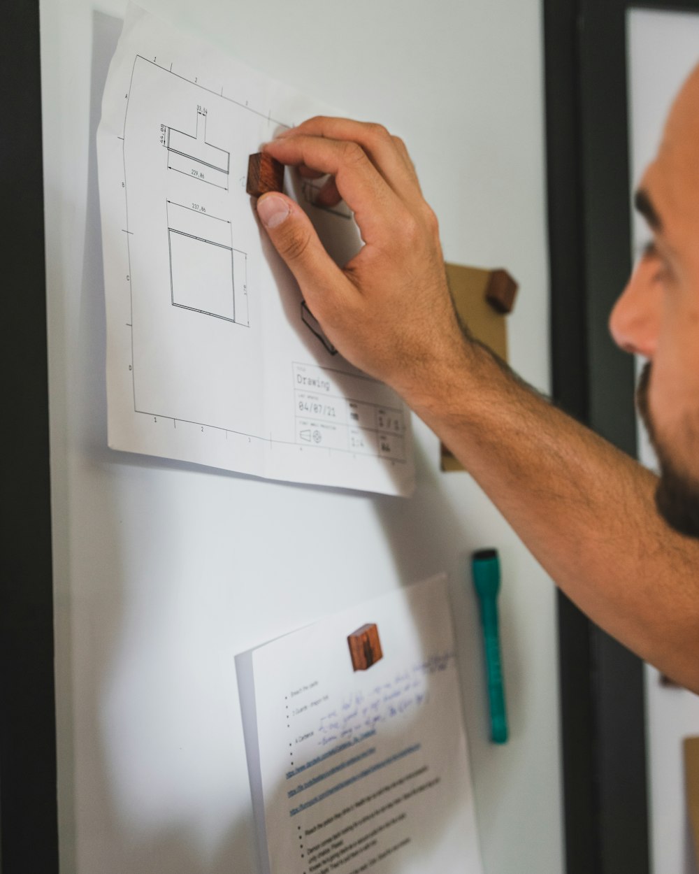 a man writing on a piece of paper on a wall