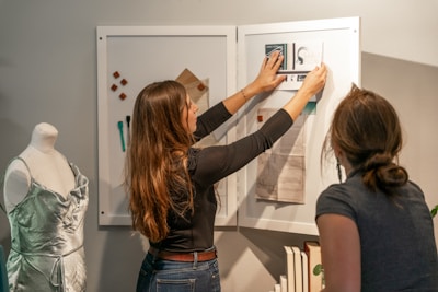 Close-up of hands arranging a picture board with various items.