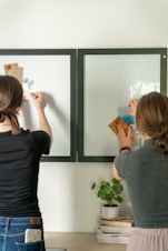 a couple of women standing in front of a mirror