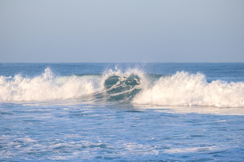 a man riding a wave on top of a surfboard