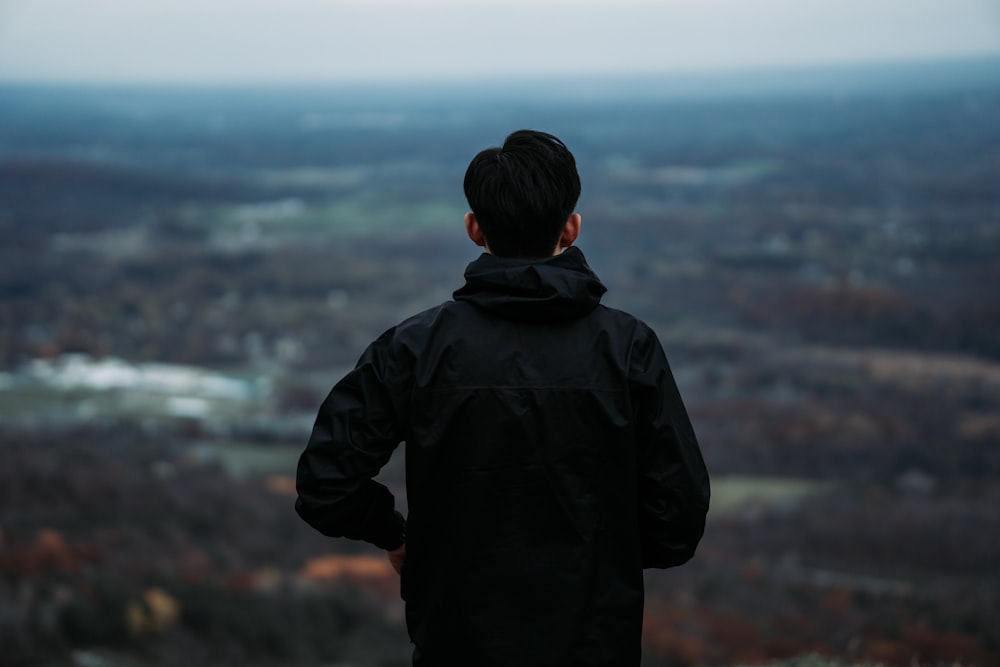 a man standing on top of a hill looking at a valley