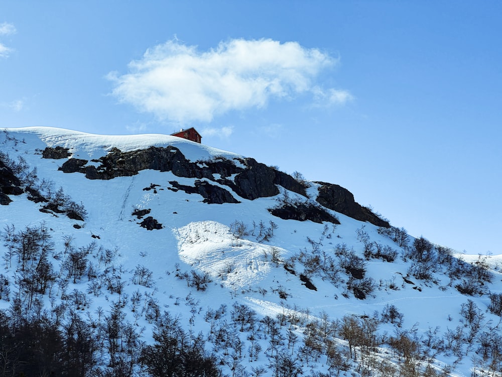 a mountain covered in snow with a house on top of it